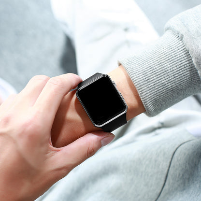Digital electronic wristwatch on wrist, black screen, dark strap, brushed metal side.
