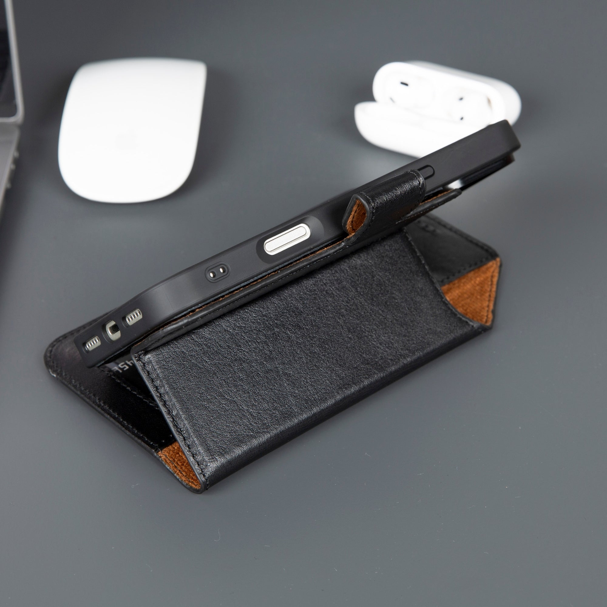 Leather iPhone wallet case with black exterior, tan accents, and side card slot view