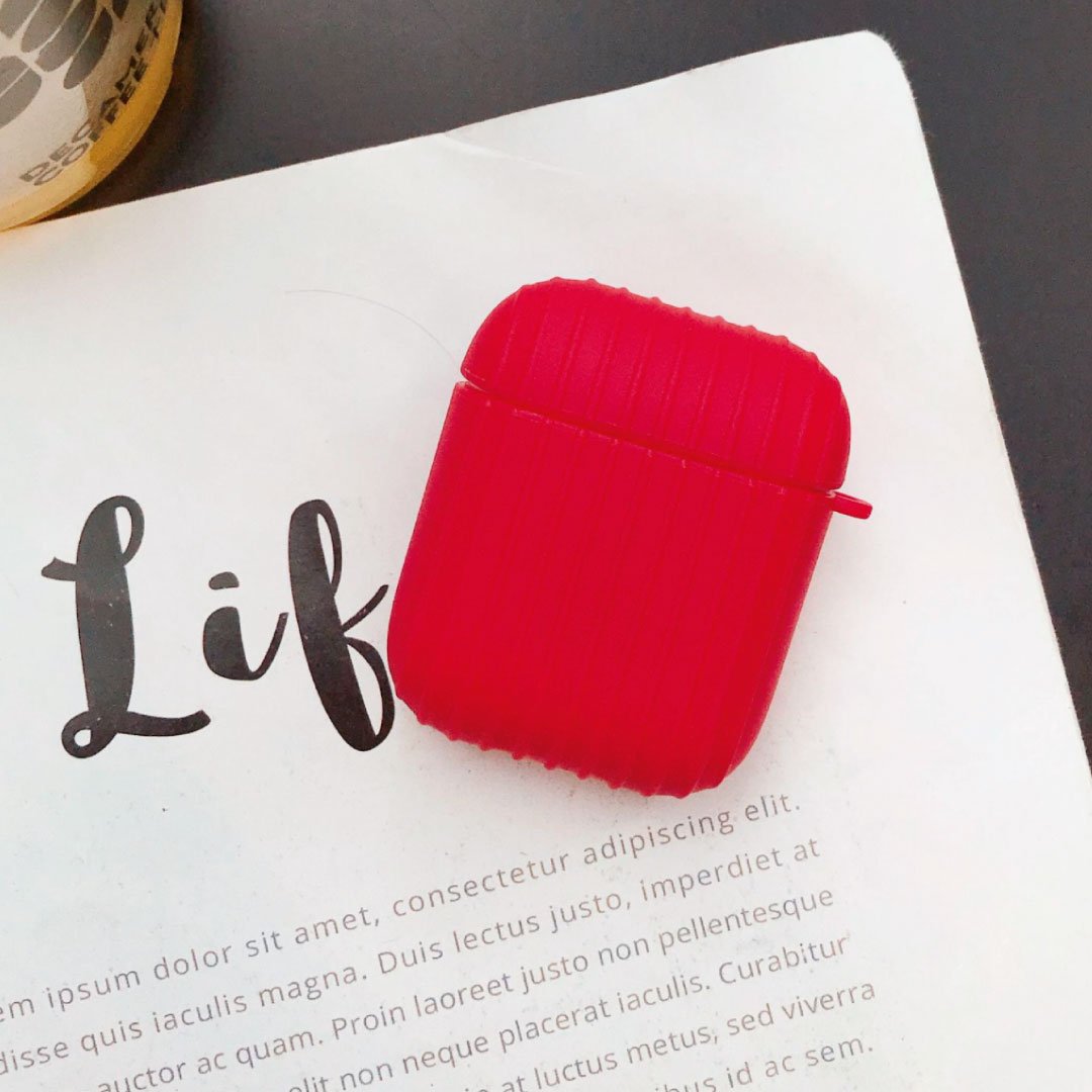Red ribbed AirPod case with small side handle, viewed from above