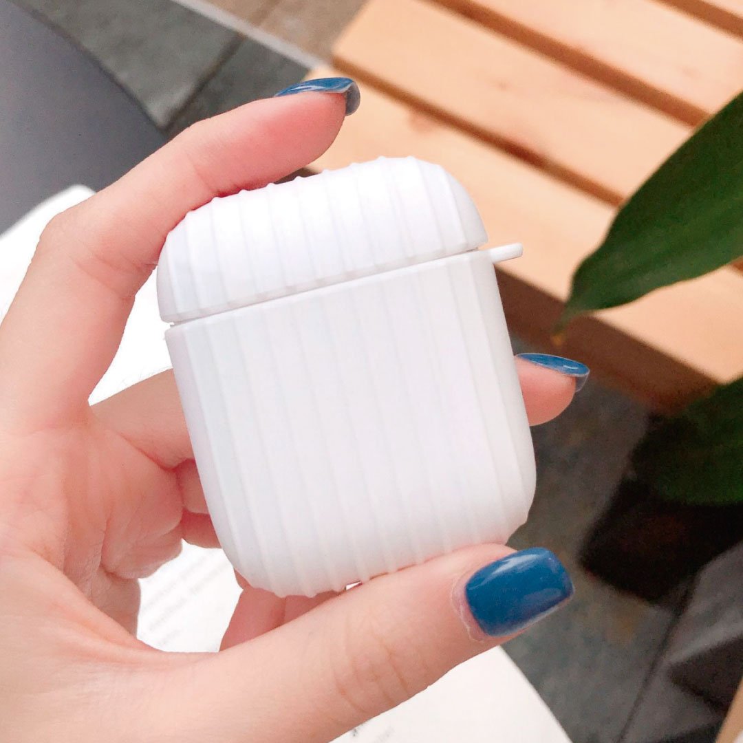 White ribbed AirPod case with small side handle, held in a hand