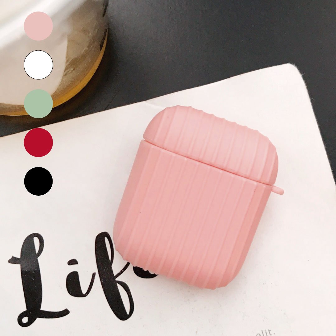 Pink ribbed AirPod case with small side handle on a white surface